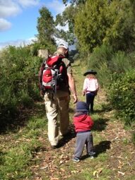 Father and children walking through a field.